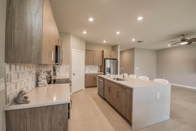 1878 NE Ocean Dunes Dr, Jensen Beach, FL 34957 - kitchen featuring stainless steel appliances, decorative backsplash, a kitchen island with sink, light countertops, and modern cabinets