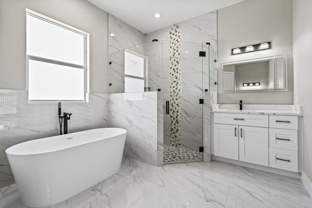 3257 SE Snow Rd, Port Saint Lucie, FL 34984 - bathroom featuring a freestanding tub, marble tiled floors, a marble finish shower, vanity, and recessed lighting