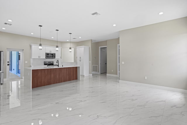 3257 SE Snow Rd, Port Saint Lucie, FL 34984 - kitchen featuring stainless steel appliances, open floor plan, light marble finish floors, recessed lighting, and light countertops