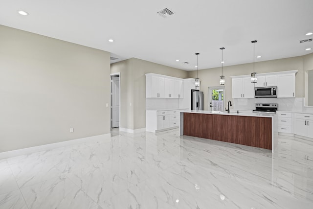 3257 SE Snow Rd, Port Saint Lucie, FL 34984 - kitchen with stainless steel appliances, recessed lighting, light countertops, white cabinetry, and an island with sink