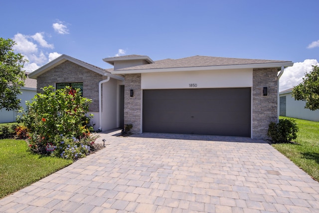1850 NE Ocean Dunes Dr, Jensen Beach, FL 34957 - view of front of house featuring stone siding, decorative driveway, and stucco siding