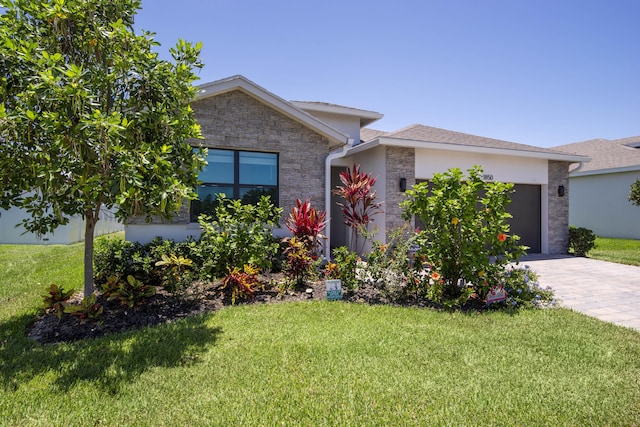 1850 NE Ocean Dunes Dr, Jensen Beach, FL 34957 - view of front of house featuring stone siding, a garage, a front yard, and driveway