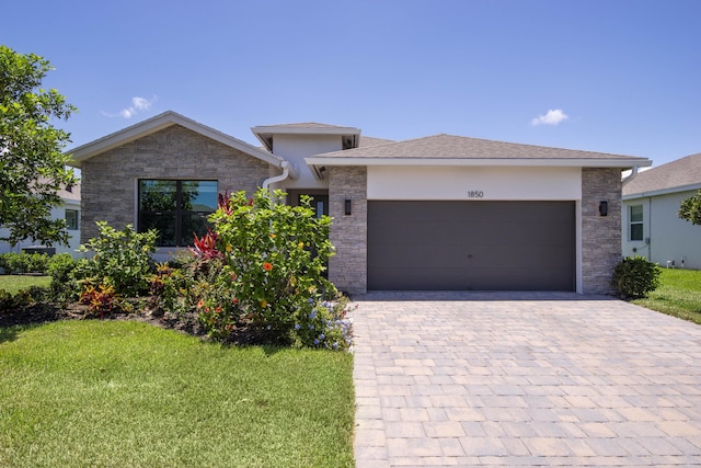 1850 NE Ocean Dunes Dr, Jensen Beach, FL 34957 - view of front of property with a garage, stone siding, and a front lawn