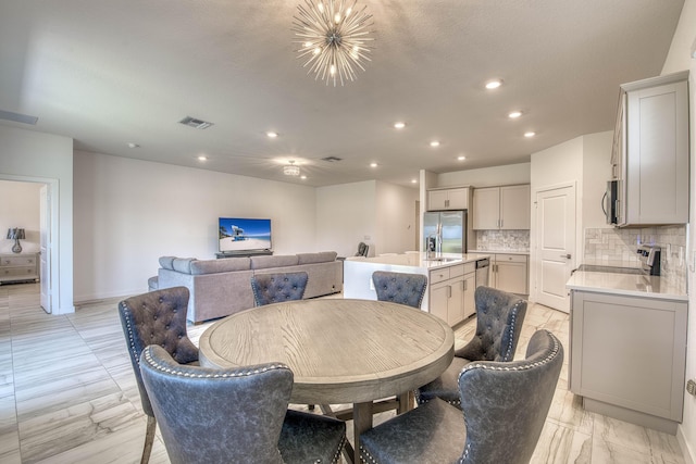 1850 NE Ocean Dunes Dr, Jensen Beach, FL 34957 - dining room with a chandelier, light marble finish flooring, and recessed lighting