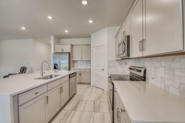 1850 NE Ocean Dunes Dr, Jensen Beach, FL 34957 - kitchen featuring appliances with stainless steel finishes, backsplash, a center island with sink, recessed lighting, and light countertops