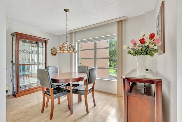 10777 W Sample Rd Unit 207, Coral Springs, FL 33065 - dining space featuring light wood-style floors and a textured ceiling