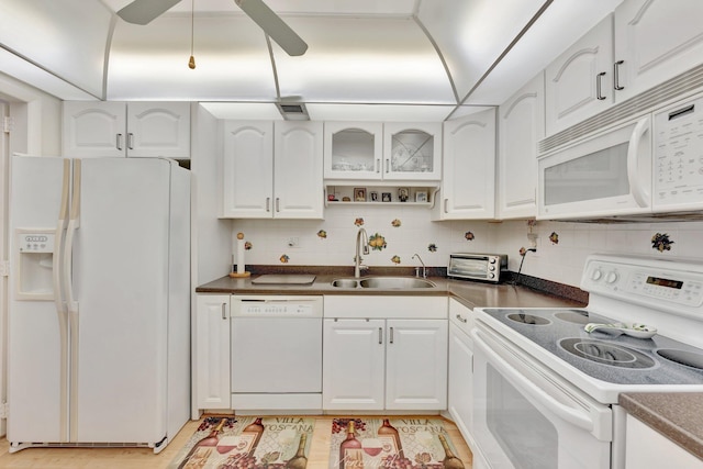 10777 W Sample Rd Unit 207, Coral Springs, FL 33065 - kitchen with white appliances, dark countertops, white cabinets, and decorative backsplash