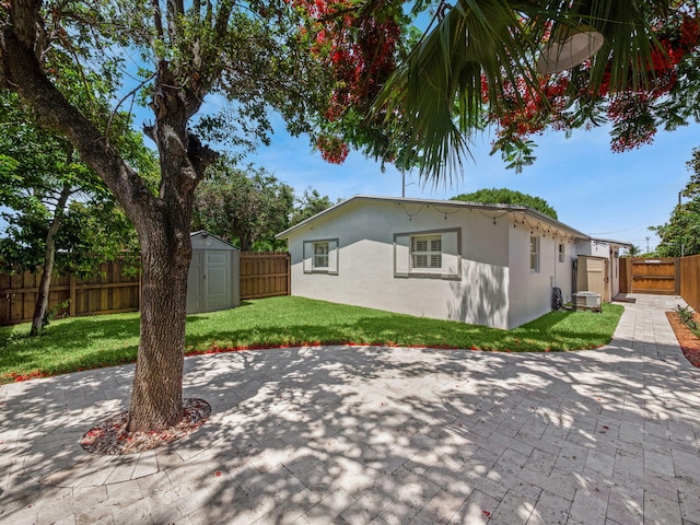 1303 NW 2nd St, Delray Beach, FL 33444 - back of house featuring a patio, a fenced backyard, stucco siding, and a storage unit