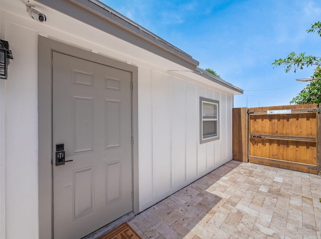 1303 NW 2nd St, Delray Beach, FL 33444 - doorway to property with board and batten siding and a gate