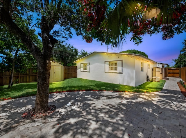 1303 NW 2nd St, Delray Beach, FL 33444 - view of property exterior with a patio, a fenced backyard, stucco siding, and a shed