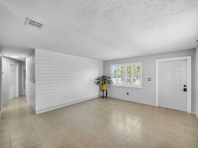 1303 NW 2nd St, Delray Beach, FL 33444 - unfurnished living room featuring a textured ceiling and tile patterned flooring