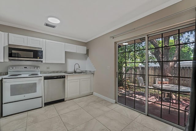 732 Neil Rd Unit 1-4, West Palm Beach, FL 33415 - kitchen featuring stainless steel appliances, ornamental molding, light countertops, healthy amount of natural light, and white cabinets