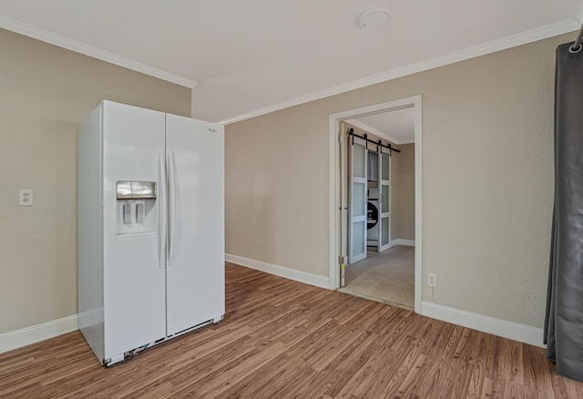 732 Neil Rd Unit 1-4, West Palm Beach, FL 33415 - kitchen featuring white fridge with ice dispenser, wood finished floors, ornamental molding, a barn door, and washer / dryer