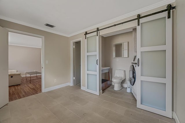 732 Neil Rd Unit 1-4, West Palm Beach, FL 33415 - unfurnished bedroom with a barn door, ornamental molding, tile patterned flooring, and washer / clothes dryer