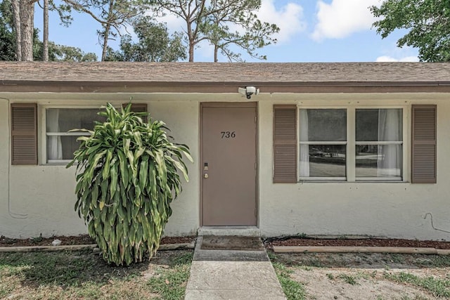 732 Neil Rd Unit 1-4, West Palm Beach, FL 33415 - view of exterior entry with stucco siding and roof with shingles