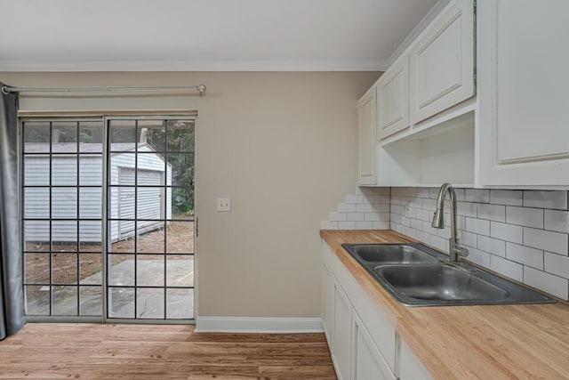 732 Neil Rd Unit 1-4, West Palm Beach, FL 33415 - kitchen featuring butcher block counters, backsplash, white cabinets, crown molding, and wood finished floors