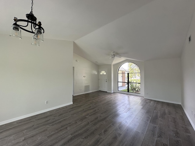 226 SW Statler Ave, Port Saint Lucie, FL 34984 - unfurnished living room with a ceiling fan, vaulted ceiling, dark wood-style flooring, and a chandelier