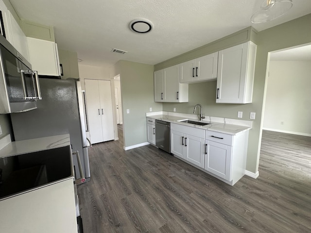226 SW Statler Ave, Port Saint Lucie, FL 34984 - kitchen featuring appliances with stainless steel finishes, dark wood finished floors, white cabinets, and light stone counters