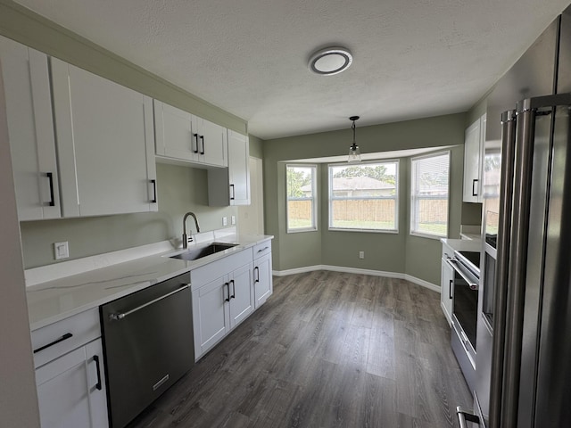 226 SW Statler Ave, Port Saint Lucie, FL 34984 - kitchen with stainless steel appliances, dark wood finished floors, white cabinetry, pendant lighting, and a textured ceiling