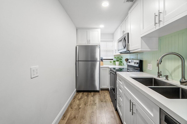 421 N Cypress Dr Unit 15, Tequesta, FL 33469 - kitchen featuring stainless steel appliances, white cabinetry, light wood-style floors, light countertops, and recessed lighting