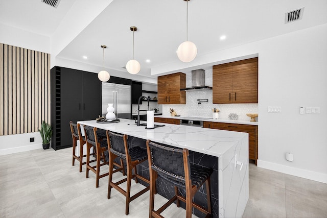 1807 NE 18th St, Fort Lauderdale, FL 33305 - kitchen featuring wall chimney exhaust hood, stainless steel built in refrigerator, tasteful backsplash, recessed lighting, and modern cabinets