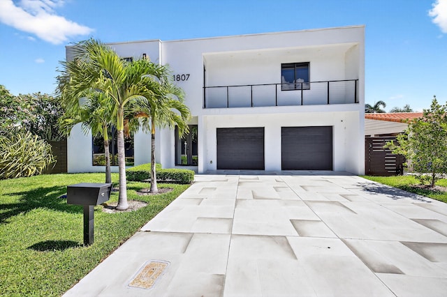 1807 NE 18th St, Fort Lauderdale, FL 33305 - contemporary home with a balcony, stucco siding, concrete driveway, a garage, and a front lawn