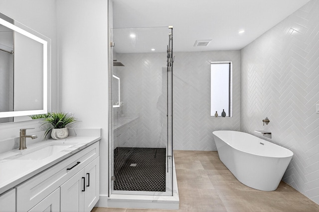 1807 NE 18th St, Fort Lauderdale, FL 33305 - full bathroom with vanity, a stall shower, a freestanding tub, tile walls, and recessed lighting