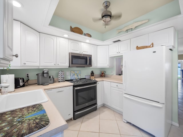 52 Yacht Club Dr Unit 103, North Palm Beach, FL 33408 - kitchen featuring appliances with stainless steel finishes, white cabinetry, light tile patterned floors, and light countertops