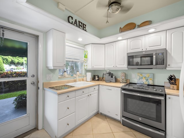 52 Yacht Club Dr Unit 103, North Palm Beach, FL 33408 - kitchen with appliances with stainless steel finishes, white cabinetry, light countertops, light tile patterned floors, and ceiling fan
