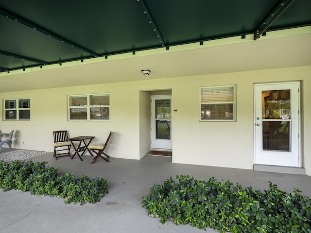 52 Yacht Club Dr Unit 103, North Palm Beach, FL 33408 - doorway to property with stucco siding and a patio area