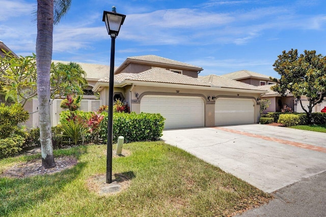 5465 Monterey D Cir Unit D, Delray Beach, FL 33484 - view of property featuring a garage, concrete driveway, stucco siding, and a tiled roof