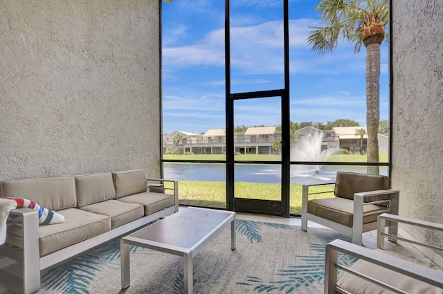 5465 Monterey D Cir Unit D, Delray Beach, FL 33484 - living area featuring a water view, plenty of natural light, a textured wall, and floor to ceiling windows