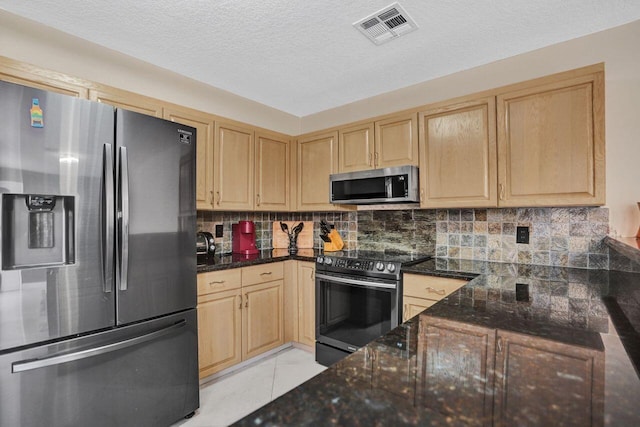 5465 Monterey D Cir Unit D, Delray Beach, FL 33484 - kitchen featuring appliances with stainless steel finishes, light brown cabinetry, tasteful backsplash, dark stone countertops, and a textured ceiling
