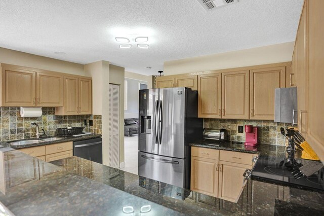 5465 Monterey D Cir Unit D, Delray Beach, FL 33484 - kitchen featuring appliances with stainless steel finishes, light brown cabinetry, dark stone counters, and a textured ceiling