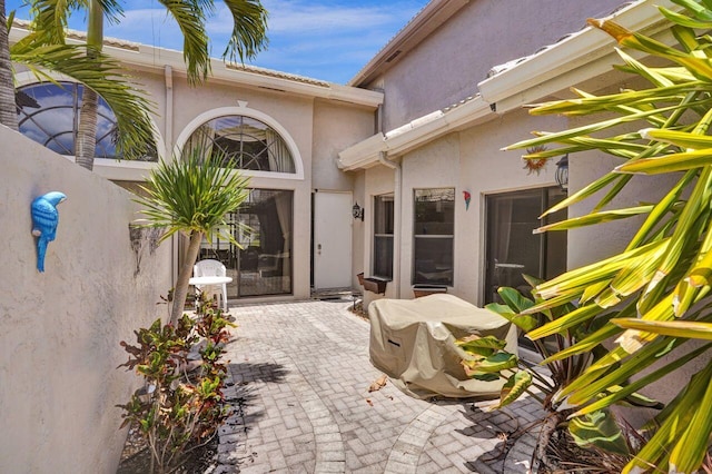 5465 Monterey D Cir Unit D, Delray Beach, FL 33484 - view of exterior entry with a patio and stucco siding