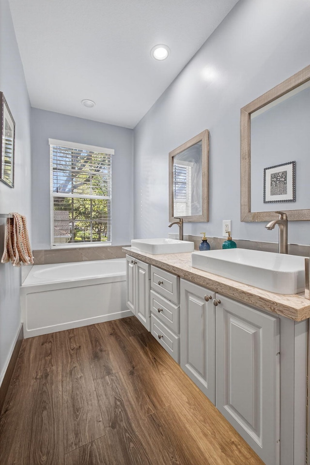 274 Murray Ct, Jupiter, FL 33458 - full bathroom featuring wood finished floors, double vanity, a garden tub, and recessed lighting