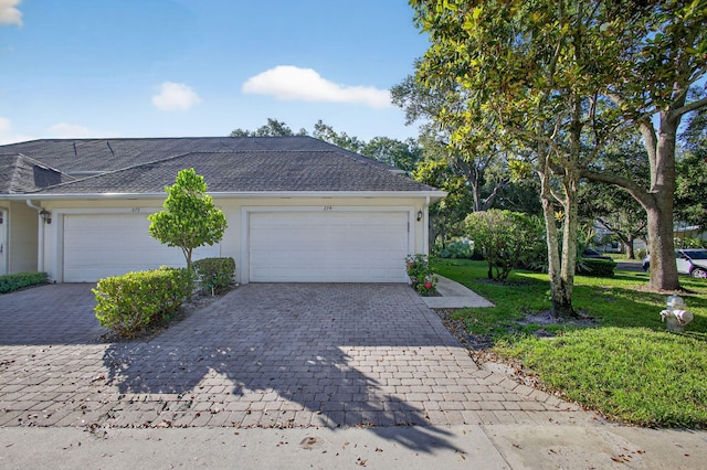 274 Murray Ct, Jupiter, FL 33458 - view of home's exterior featuring decorative driveway, a lawn, stucco siding, a garage, and a shingled roof