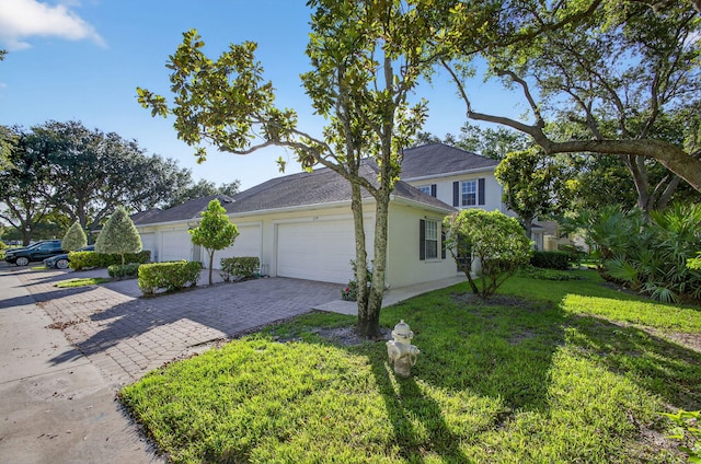 274 Murray Ct, Jupiter, FL 33458 - view of side of home with an attached garage, decorative driveway, a lawn, and stucco siding
