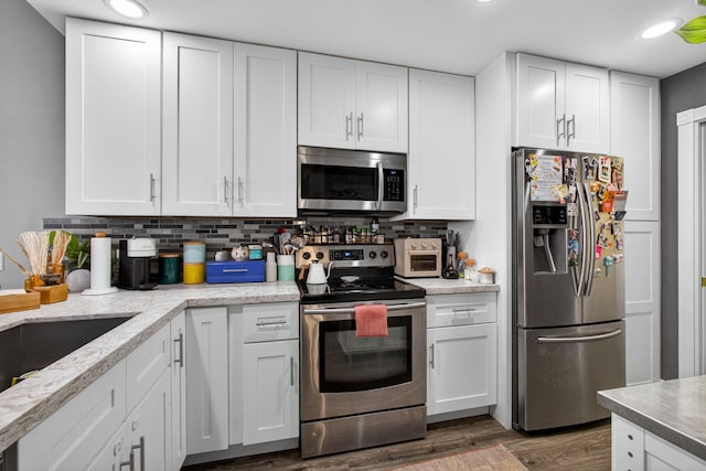 274 Murray Ct, Jupiter, FL 33458 - kitchen with appliances with stainless steel finishes, wood finished floors, white cabinets, backsplash, and recessed lighting