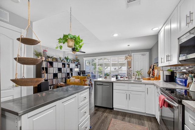 274 Murray Ct, Jupiter, FL 33458 - kitchen featuring appliances with stainless steel finishes, recessed lighting, dark wood finished floors, white cabinets, and a peninsula