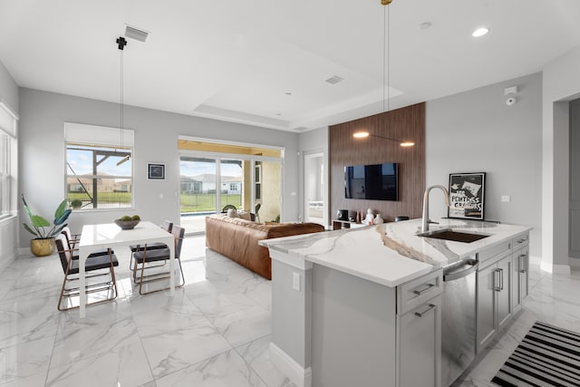 12136 SW Fortezza Way, Port Saint Lucie, FL 34987 - kitchen featuring light marble finish floors, stainless steel dishwasher, light stone countertops, open floor plan, and decorative light fixtures