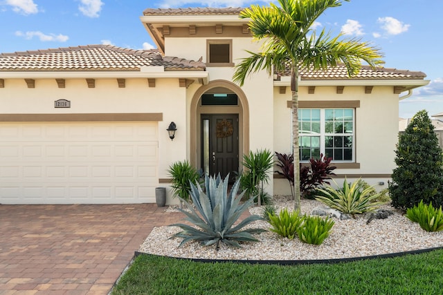 12136 SW Fortezza Way, Port Saint Lucie, FL 34987 - mediterranean / spanish home with stucco siding, a tile roof, decorative driveway, and a garage