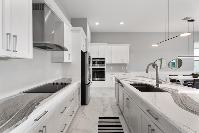 12136 SW Fortezza Way, Port Saint Lucie, FL 34987 - kitchen featuring wall chimney exhaust hood, stainless steel appliances, light marble finish floors, white cabinetry, and decorative light fixtures