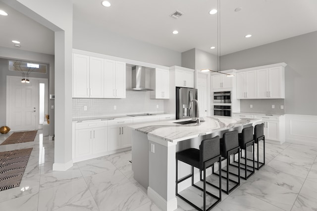 12136 SW Fortezza Way, Port Saint Lucie, FL 34987 - kitchen featuring wall chimney exhaust hood, light marble finish flooring, appliances with stainless steel finishes, white cabinets, and recessed lighting