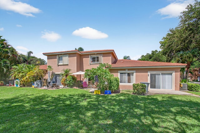 9931 Kamena Cir, Boynton Beach, FL 33436 - rear view of property featuring a tiled roof, stucco siding, and a yard