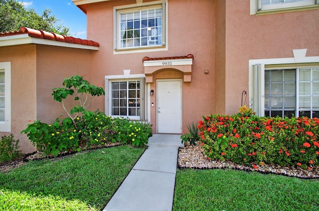 9931 Kamena Cir, Boynton Beach, FL 33436 - property entrance featuring stucco siding and a yard