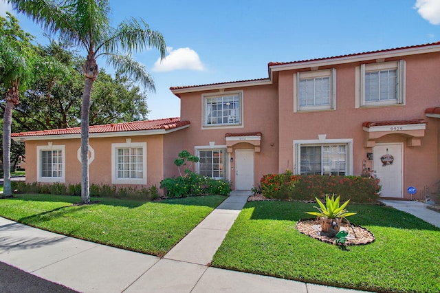 9931 Kamena Cir, Boynton Beach, FL 33436 - view of front of house with stucco siding, a front lawn, and a tiled roof