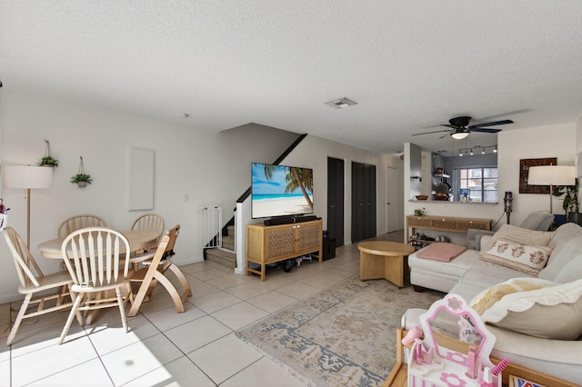 9931 Kamena Cir, Boynton Beach, FL 33436 - living area with a textured ceiling, ceiling fan, light tile patterned floors, and stairs