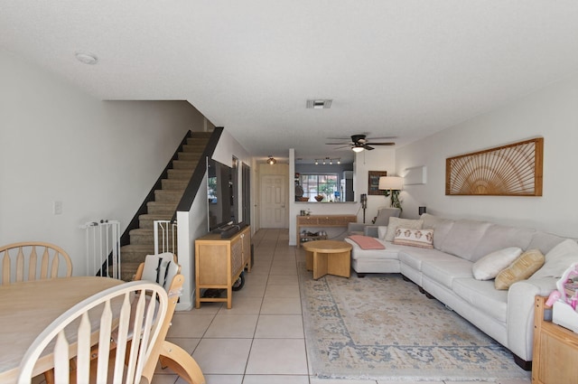 9931 Kamena Cir, Boynton Beach, FL 33436 - living room featuring ceiling fan, light tile patterned flooring, and stairs