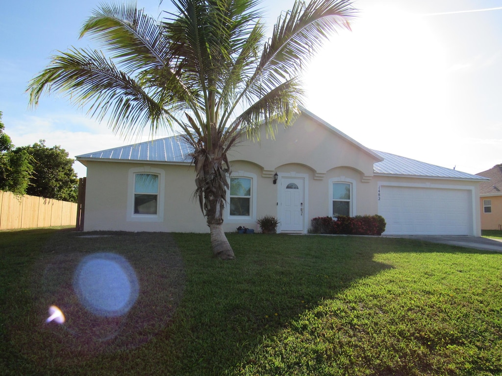 1482 SE Kirke Ln, Port Saint Lucie, FL 34983 - ranch-style house featuring stucco siding, a garage, a metal roof, and concrete driveway